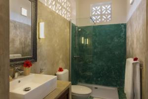 y baño con lavabo y ducha acristalada. en Zanzibar Magic Boutique Hotel, en Matemwe