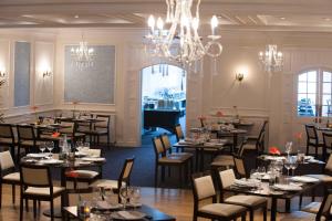 a dining room with tables and chairs and a chandelier at Hythe Imperial Hotel, Spa & Golf in Hythe