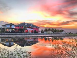 uma casa na margem de um lago ao pôr-do-sol em MiCarro B&B em Dongshan