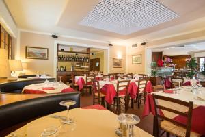 ein Restaurant mit Tischen und Stühlen mit roten Servietten in der Unterkunft Hotel Tre Castelli in Gallicano