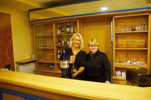 two women standing behind a counter in a bar at Hotel Alberga in Mettmann