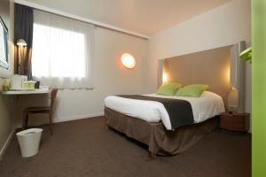 a bedroom with a large bed with green pillows at Campanile Nantes Centre - Saint Jacques in Nantes