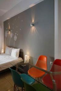 アテネにあるOmonoia Boutique Apartmentのベッド、椅子、テーブルが備わる客室です。