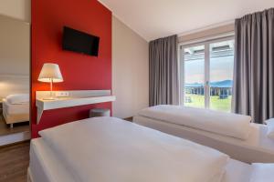 Una habitación de hotel con dos camas y una ventana. en Hotel Irschenberg Süd, en Irschenberg