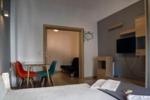 アテネにあるOmonoia Boutique Apartmentのベッドルーム1室(ベッド1台、テーブル、椅子付)