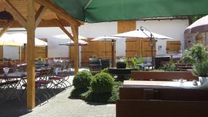 a restaurant with tables and chairs and umbrellas at Landgasthof & Landhotel Wild in Haunwang