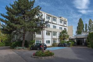 a building with a car parked in front of it at Mercure Paris Sud Les Ulis-Courtaboeuf in Les Ulis