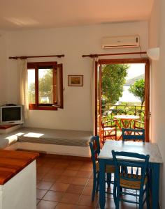 sala de estar con cama, mesa y sillas en Mealos Apartments, en Skiros