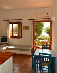 a living room with a bed and a table and chairs at Mealos Apartments in Skiros