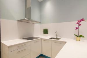 a white kitchen with white cabinets and a sink at Luxury Alonso Martinez Madrid in Madrid