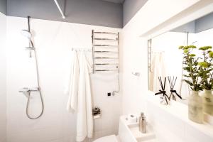 a white bathroom with a shower and a sink at Art Apartments Rynok Square in Lviv +20 photos