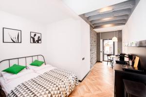 1 dormitorio con 1 cama con almohadas verdes en Art Apartments Rynok Square, en Leópolis