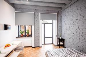 a bedroom with a white brick wall and a bed at Art Apartments Rynok Square in Lviv