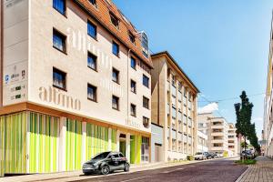une petite voiture garée devant un bâtiment dans l'établissement attimo Hotel Stuttgart***S, à Stuttgart