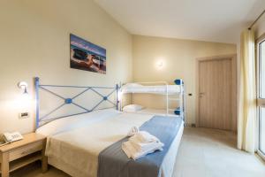ein Schlafzimmer mit einem Bett mit zwei Handtüchern darauf in der Unterkunft Hotel Mar & Sol in Punta Secca