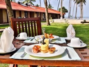 a table with a plate of food on it at Amagi Beach – Secluded Slice of Paradise in Marawila