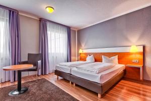 Кровать или кровати в номере attimo Hotel Stuttgart***S