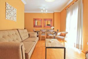salon z kanapą i stołem w obiekcie Del Parque Flats - Cervantes w Maladze