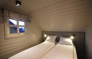 two beds in a small room with a window at Bleik Sea Cabins in Bleik