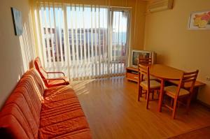 a living room with a couch and a table and a television at GT Privilege Fort Beach Apartments in Elenite