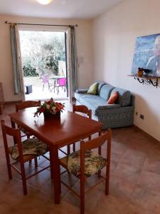 a living room with a table and chairs and a couch at Gli Ulivi in Valledoria