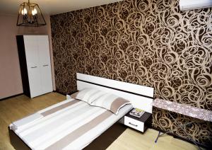 - une chambre avec un lit et un mur recouvert de papier peint dans l'établissement ATLANT Apartments 111, à Voronej