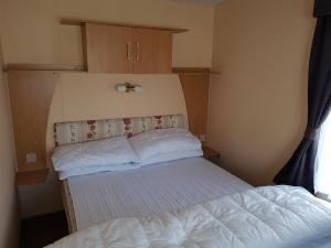 a small bedroom with two beds and a window at 6 Berth with Sea Views on Beachside in Brean