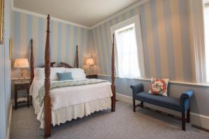a bedroom with a bed and a chair and a window at Captain Farris House in South Yarmouth