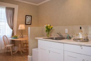 a kitchen with a sink and a table with wine glasses at Captain Farris House in South Yarmouth