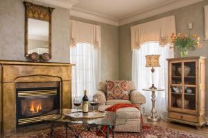a living room with a fireplace and a chair at Captain Farris House in South Yarmouth