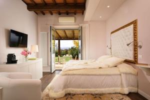 a white bedroom with a large bed and a chair at Anna Boccali Resort in Corciano