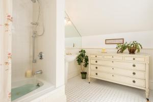 a bathroom with a bath tub and a dresser at Captain Farris House in South Yarmouth +27 photos