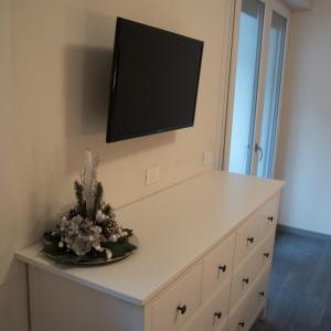 een witte dressoir met een televisie aan de muur bij Hotel Italia in Aprica