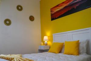 a bedroom with a white bed with yellow walls at Vista do Norte - Northern View! in Santo António