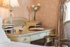 a desk with a lamp and a vase of flowers on it at Captain Farris House in South Yarmouth