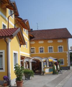 a yellow building with a street in front of it at Kirchenwirt Mayr in Franking