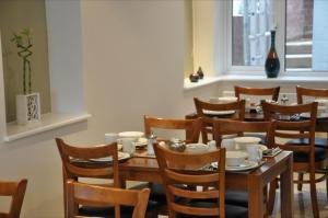 a dining room with a wooden table and chairs at Queens Hotel in London