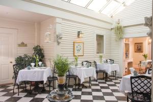 uma sala de jantar com duas mesas e um piso xadrez em Captain Farris House em South Yarmouth