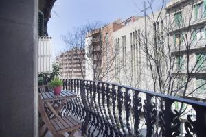 een balkon met twee banken op een leuning met gebouwen bij ApartEasy - Authentic Family Apartment in Barcelona