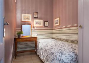 バルセロナにあるApartEasy - Family Sant Antoni apt.のベッドルーム1室(ベッド1台、鏡付き洗面化粧台付)