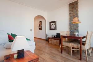 - un salon avec une table et un canapé dans l'établissement ApartEasy - Atic Sagrada Familia, à Barcelone