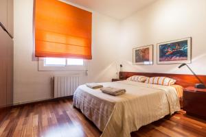 Schlafzimmer mit einem Bett und einem Fenster in der Unterkunft ApartEasy - Port Barcelona in Barcelona