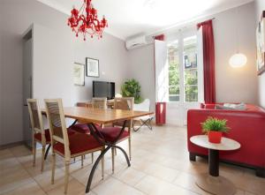 バルセロナにあるApartEasy - Family Sant Antoni apt.のリビングルーム(ダイニングテーブル、赤いソファ付)