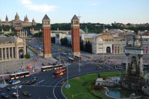 a city with buses and cars on a street at ApartEasy - Plaza España Deluxe in Barcelona