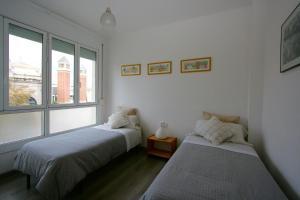 a bedroom with two beds and a window at ApartEasy - Plaza España Deluxe in Barcelona