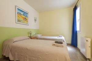 バルセロナにあるApartEasy - Family Apartment Sant Antoniのベッド2台と窓が備わる小さな客室です。