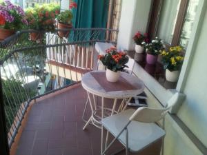 een tafel en stoelen op een balkon met potplanten bij ApartEasy - Family Apartment Sant Antoni in Barcelona