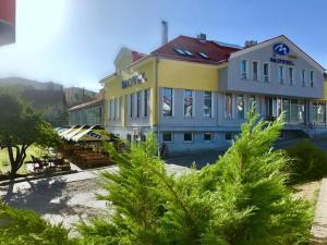 a large building with trees in front of it at Motel M in Vlasenica