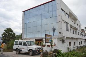 a white truck parked in front of a building at Hotel Maurya Vihar Bodhgaya in Bodh Gaya