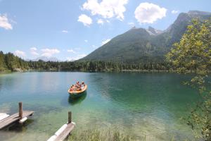 un groupe de personnes dans un bateau sur un lac dans l'établissement Haus am See, à Ramsau bei Berchtesgaden